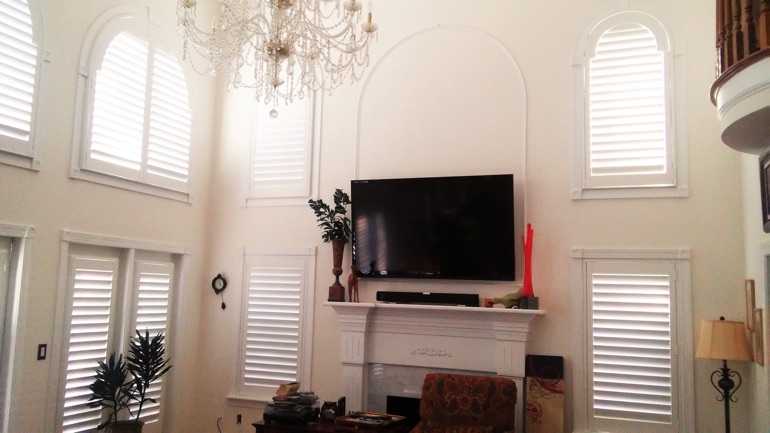 Cincinnati great room with mounted TV and high-ceiling windows.